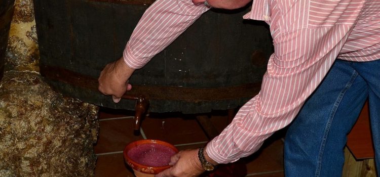 Hombre sirviendo vino en una cunca
