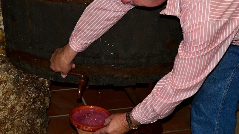 Hombre sirviendo vino en una cunca